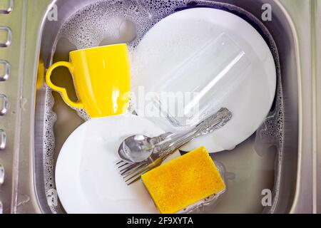 Lavandino in metallo in cucina pieno di stoviglie sporche. Casalinghi, piatti di lavaggio, concetto di compiti domestici. Foto Stock