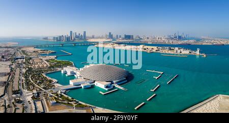 Abu Dhabi, Emirati Arabi Uniti - 6 aprile 2021: Museo del Louvre e paesaggio urbano aereo di Abu Dhabi che si innalzano dalle acque marine dell'Emirati Arabi Uniti Foto Stock