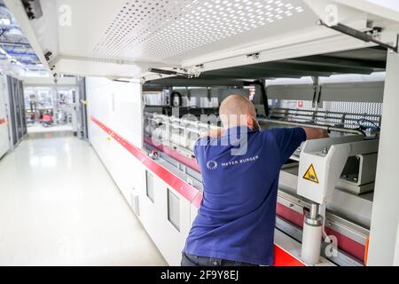 Freiberg, Germania. 21 Apr 2021. Un dipendente crea i laminatori lunghi 12 metri presso la nuova sede del produttore di moduli solari Meyer Burger. Lo stabilimento sarà ufficialmente aperto qui dal 26 maggio. Questo è quasi esattamente dieci anni dopo l'apertura di SolarWorld. Le macchine sono attualmente in fase di installazione e le linee di produzione sono state preparate. Lo scorso anno la società svizzera aveva rilevato lo stabilimento del produttore di moduli solari SolarWorld in fallimento a Freiberg. Credit: Jan Woitas/dpa-Zentralbild/ZB/dpa/Alamy Live News Foto Stock