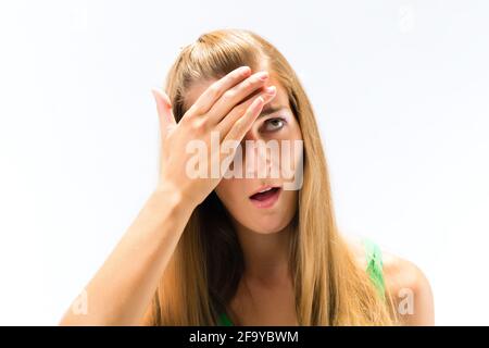 Ritratto di giovane donna che ha mal di testa guardando verso il bianco sfondo Foto Stock