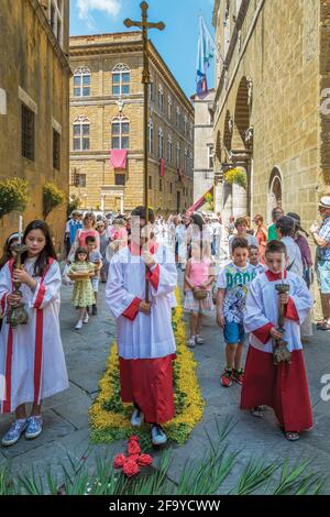 Pienza, Provincia di Siena, Toscana, Italia. Processione del Corpus Christi con i giovani devoti che portano regalia. Il centro storico della città di Pienza è Foto Stock