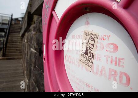 Cardiff, Galles, Regno Unito. 21 Apr 2021. Un adesivo anti-vaccinazione a nome della Rosa Bianca è raffigurato su un anello di emergenza sul lungomare della baia di Cardiff. Credit: Mark Hawkins/Alamy Live News Foto Stock