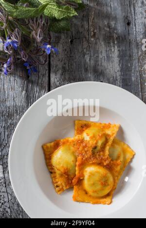 Ravioli fatti in casa farciti con borragine e patate condite con piatti vegetariani ragù Foto Stock
