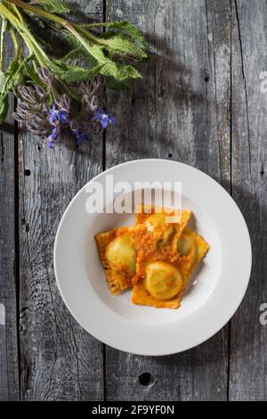 Ravioli fatti in casa farciti con borragine e patate condite con piatti vegetariani ragù Foto Stock