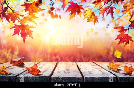 Sfondo autunno - Tavola di legno con foglie rosse Foto Stock