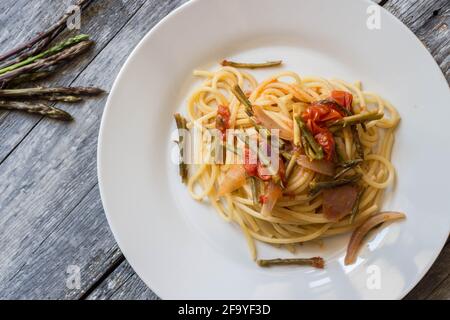 Spaghetti con pomodori ciliegini e asparagi selvatici Foto Stock