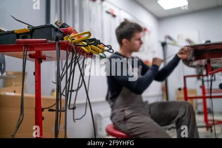 Rimozione delle ammaccature processo di lavoro di un giovane datore di lavoro professionale di riparazione auto Foto Stock