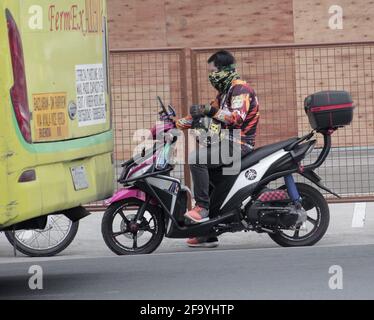 San Jose del Monte, Filippine. 21 Apr 2021. Un motociclista che indossa il suo facciale alla moda mentre si riposa in uno dei marciapiedi a San Jose del Monte, Filippine. (Foto di John Mark Aeron Pineda/Pacific Press) Credit: Pacific Press Media Production Corp./Alamy Live News Foto Stock