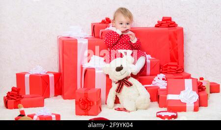 Doni per i bambini prima di natale. Celebrare prima di natale. Little Baby girl giocare vicino a pila di confezioni regalo. Vacanza in famiglia. Cose da fare con i bambini Foto Stock