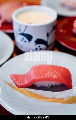 Sushi e Sashimi. Piatti di Sushi e Sashimi rotolando su nastro trasportatore. Foto Stock