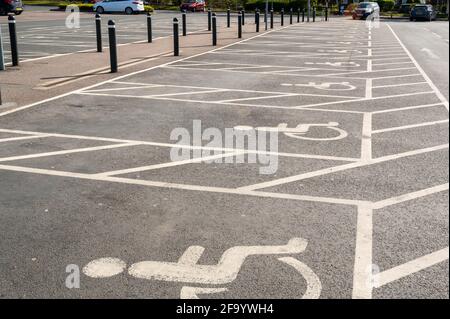 Posto auto per disabili o vano, riservato a persone con disabilità e spazio extra per caricare una sedia a rotelle in un parcheggio per un supermercato Foto Stock