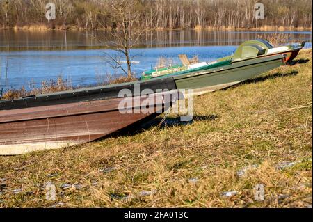 Alcune piccole imbarcazioni da pesca abbandonate si trovano sulla riva del Danubio. Foto Stock