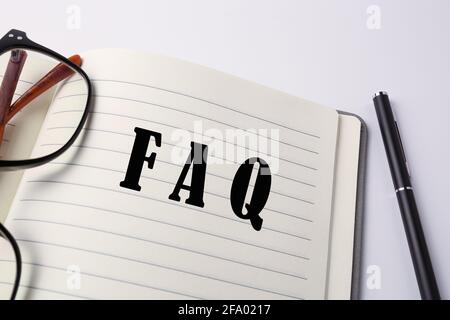 FAQ scritte su un notebook. Foto Stock