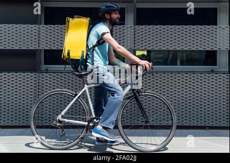 giovane uomo di consegna con concetto di takeaway con zaino giallo Foto Stock