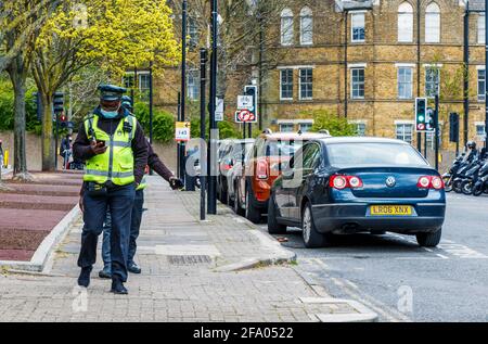 Due operai che pattugliano la zona di parcheggio controllata in Archway, Nord Islington, Londra, Regno Unito Foto Stock