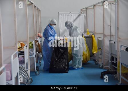 Tunisi, Tunisia. 21 Apr 2021. Operatori sanitari che indossano dispositivi di protezione individuale visto presso l'ospedale di campo nel distretto di Menzah, un complesso sportivo che è stato convertito per il trattamento dei crescenti casi COVID-19. In Tunisia, 93 persone sono morte, mentre 2,169 persone hanno contratto COVID-19, spingendo il pedaggio a 9,918 e 289,230 rispettivamente. I recuperi totali hanno raggiunto 239,104 con 2,511 aggiunte. Credit: SOPA Images Limited/Alamy Live News Foto Stock