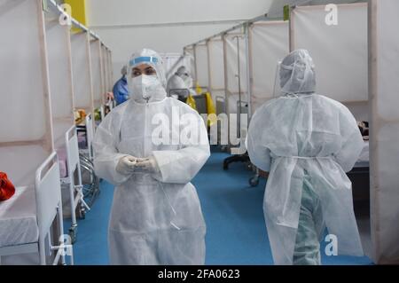 Tunisi, Tunisia. 21 Apr 2021. Operatori sanitari che indossano dispositivi di protezione individuale visto presso l'ospedale di campo nel distretto di Menzah, un complesso sportivo che è stato convertito per il trattamento dei crescenti casi COVID-19. In Tunisia, 93 persone sono morte, mentre 2,169 persone hanno contratto COVID-19, spingendo il pedaggio a 9,918 e 289,230 rispettivamente. I recuperi totali hanno raggiunto 239,104 con 2,511 aggiunte. Credit: SOPA Images Limited/Alamy Live News Foto Stock