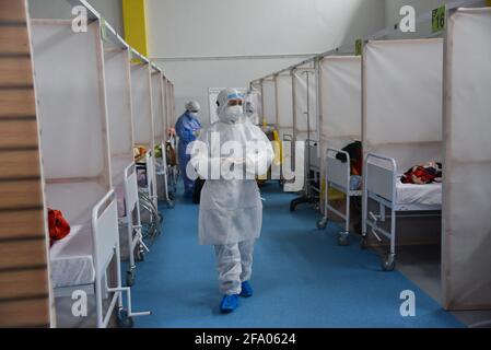 Tunisi, Tunisia. 21 Apr 2021. TUNISI, TUNISIA - Aprile 21: I medici sono visti come controllano i pazienti infettati con il nuovo tipo di coronavirus (COVID-19), presso l'ospedale di campo a Menzah distretto di Tunisi, Tunisia il 21 aprile 2021. La comlpex sportiva è stata convertita in un ospedale da campo per l'uso nel trattamento di casi COVID-19 in aumento. In Tunisia, 93 persone sono morte, mentre 2,169 persone hanno contratto COVID-19, spingendo il pedaggio a 9,918 e 289,230 rispettivamente. I recuperi totali hanno raggiunto 239,104 con 2,511 aggiunte. Credit: SOPA Images Limited/Alamy Live News Foto Stock