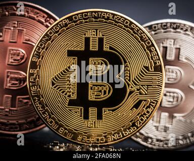 Monete di bronzo, argento e oro bitcoin in piedi sulla scheda di circuito del computer, primo piano. Foto Stock