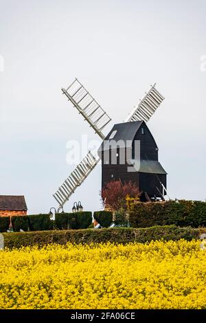 Dale Abbey, Ilkeston, UK, aprile, 18,2021: Il mulino a vento di gatto e violino nel paesaggio rurale in primavera raffigurato con un campo di ravizzone. Foto Stock