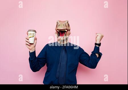 Uomo con testa di dinosauro che tiene una tazza di caffè Foto Stock