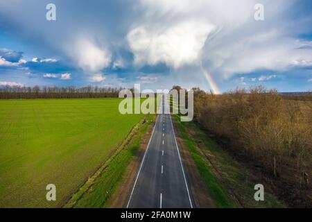 Rainbow sopra strada rurale primavera paesaggio vista aerea Foto Stock