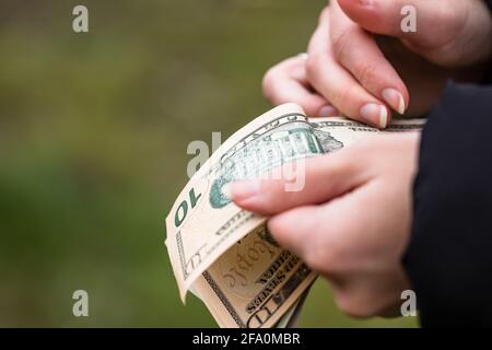 Closeup delle mani femminili che contano le banconote in USD - il denaro mondiale, l'inflazione e il concetto di economia Foto Stock