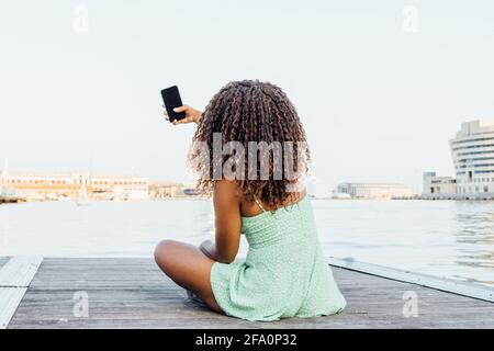 donna africana prende un selfie dal mare Foto Stock