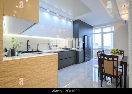 Interni di lusso con cucina moderna bianca e grigio scuro Foto Stock