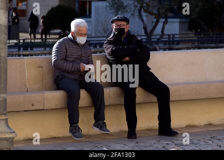 Matera, Italia. 21 Apr 2021. Due anziani che indossano maschere per il viso come precauzione contro la diffusione della chiacchierata di Covid-19 seduti in Piazza Vittorio Veneto, nel centro della città di Matera, Conosciuta come la Città di Stones. La città fu la capitale europea della Cultura nel 2019 e perse tutto il suo flusso turistico a causa della pandemia del coronavirus. (Foto di Vincenzo Nuzzolese/SOPA Images/Sipa USA) Credit: Sipa USA/Alamy Live News Foto Stock