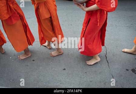 Chiang Rai, Thailandia - 13 aprile 2021: Al Songkran festival, i monaci a piedi e ricevere offerte di cibo che portano avanti come nuovo normale durante COVID-19. Foto Stock