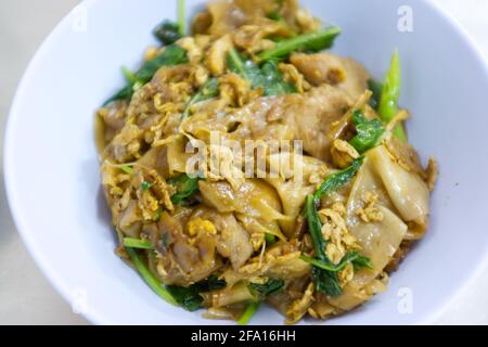 Noodles di riso fritti in padella con salsa di soia e maiale Foto Stock