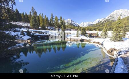 Panorama delle Montagne Rocciose Canadesi Springtime. Blue Lake e le vette delle montagne Snowy in lontananza sull'orizzonte all'Ink Pots Hiking Trail, Banff National Park Foto Stock