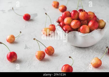 Ciotola bianca con ciliegie dolci d'arancia mature di tipo 'reale anne' su sfondo bianco Foto Stock