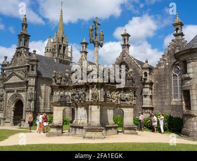 Turisti che visitano il recinto parrocchiale di Guimiliau intorno alla chiesa di Saint-Miliau. Bretagna, Francia. Foto Stock