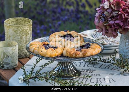 Galette di mirtillo fatte in casa su un bel tavolo decorato nel giardino estivo, lavanda sullo sfondo Foto Stock