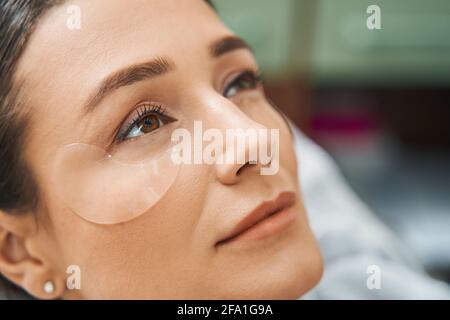 Signora con una maschera oculare persa in riverie Foto Stock