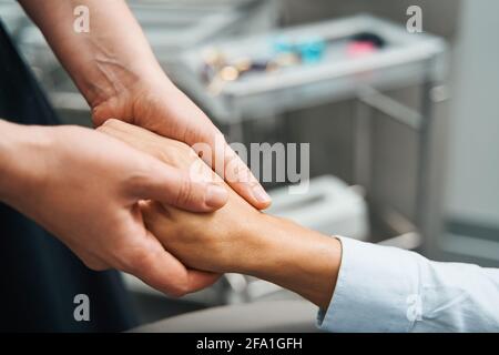 Beauty Therapist che esegue una procedura di ringiovanimento sulla sua pelle del cliente Foto Stock