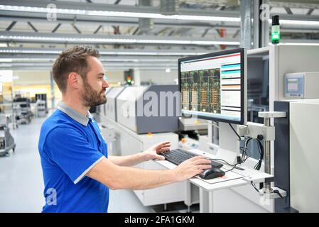 In ingegneria microelettronica: i lavoratori nella produzione e assemblaggio di electronic high tech componenti in un moderno stabilimento Foto Stock