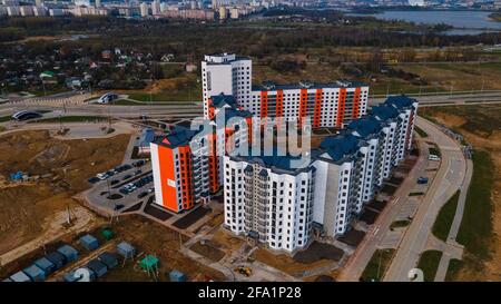 Volo sopra il cantiere. Nuovo edificio cittadino. Costruzione di edifici a più piani con pannelli. Foto Stock