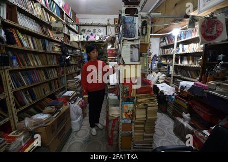 (210422) -- HEFEI, 22 aprile 2021 (Xinhua) -- Chen Guixia tidies le librerie alla libreria Zengzhi di Hefei, provincia di Anhui, nella Cina orientale, 19 aprile 2021. Sin dalla sua apertura 21 anni fa, Zengzhi Bookshop, un non descritto rivenditore di libri di seconda mano nel centro di Hefei, è stato salutato come un punto di riferimento intellettuale tra i fan del libro locale. Il suo proprietario ritardato, Zhu Chuanguo, vantava una collezione di 20,000-strong libri usati, tutti che erano stati acquistati dai lettori ordinari e riciclando i Outlets.Under la visione di Zhu, i propri libri gettati-fuori possono risultare essere illuminanti a qualcun altro che quindi merita uno Foto Stock