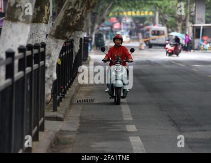 (210422) -- HEFEI, 22 aprile 2021 (Xinhua) -- Chen Guixia guida uno scooter sulla sua strada per Zengzhi Bookshop a Hefei, provincia di Anhui, Cina orientale, 20 aprile 2021. Sin dalla sua apertura 21 anni fa, Zengzhi Bookshop, un non descritto rivenditore di libri di seconda mano nel centro di Hefei, è stato salutato come un punto di riferimento intellettuale tra i fan del libro locale. Il suo ultimo proprietario, Zhu Chuanguo, vantava una collezione di 20,000-strong libri usati, tutti che erano stati acquistati dai lettori ordinari e riciclando i Outlets.Under Zhu's visione, uno dei libri gettati-fuori può risultare essere illuminante a qualcun altro che quindi meritare Foto Stock