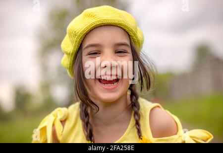 Ritratto di una piccola adorabile ragazza felice dentro una berta di maglia gialla Foto Stock