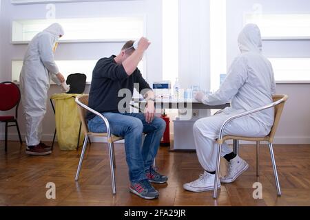 Dresda, Germania. 22 Apr 2021. Un dipendente del Corona Test Center del Parkhotel Dresden prepara un test rapido. Un uomo che vuole essere testato toglie la sua maschera protettiva. Credit: Sebastian Kahnert/dpa-Zentralbild/dpa/Alamy Live News Foto Stock