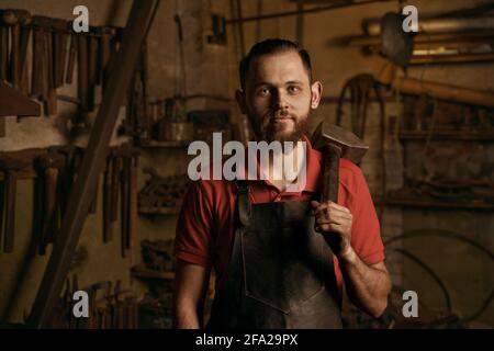 Fabbro con martello in officina closeup ritratto Foto Stock