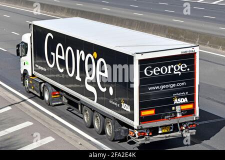 Vista laterale posteriore e superiore del camion supermercato Asda E un logo George abbigliamento marchio di moda su articolato Rimorchio della catena di fornitura sull'autostrada del Regno Unito Foto Stock