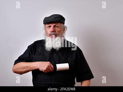 Uomo anziano in ordine che pulisce la camicia con un rullo di pelucchi Foto Stock