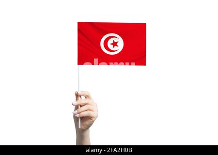 Bella mano femminile che tiene bandiera Tunisia, isolato su sfondo bianco. Foto Stock