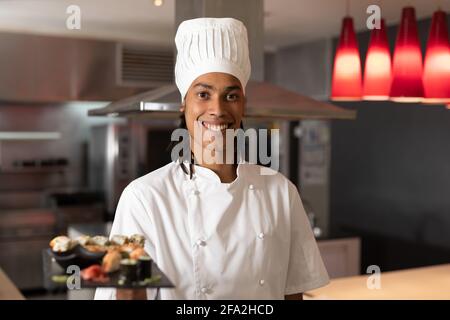 Ritratto di chef professionista di razza mista che indossa cappelli da chef sushi Foto Stock