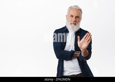 Nessun Grazie. Serio vecchio uomo di stile scuotendo la mano nel rifiuto, respingendo l'offerta, disgradendo qualcosa, osservando riluttante e la proposta di declino, in piedi sopra Foto Stock